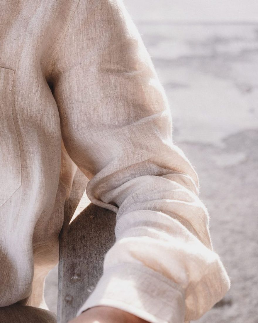 Close-up of a rolled linen shirt sleeve in soft sunlight