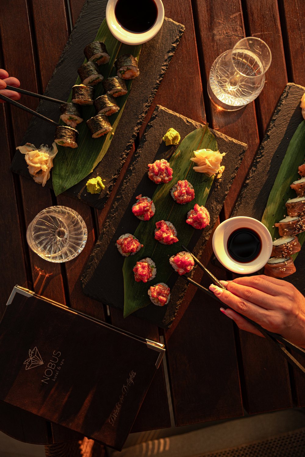 Sushi and tuna tartare on slate with the Nobus Drinks & Delights menu