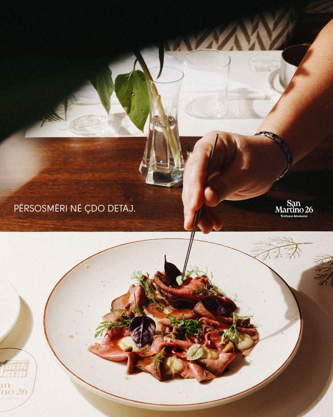 Chef finishing a beef carpaccio with tweezers: Përsosmëri në çdo detaj