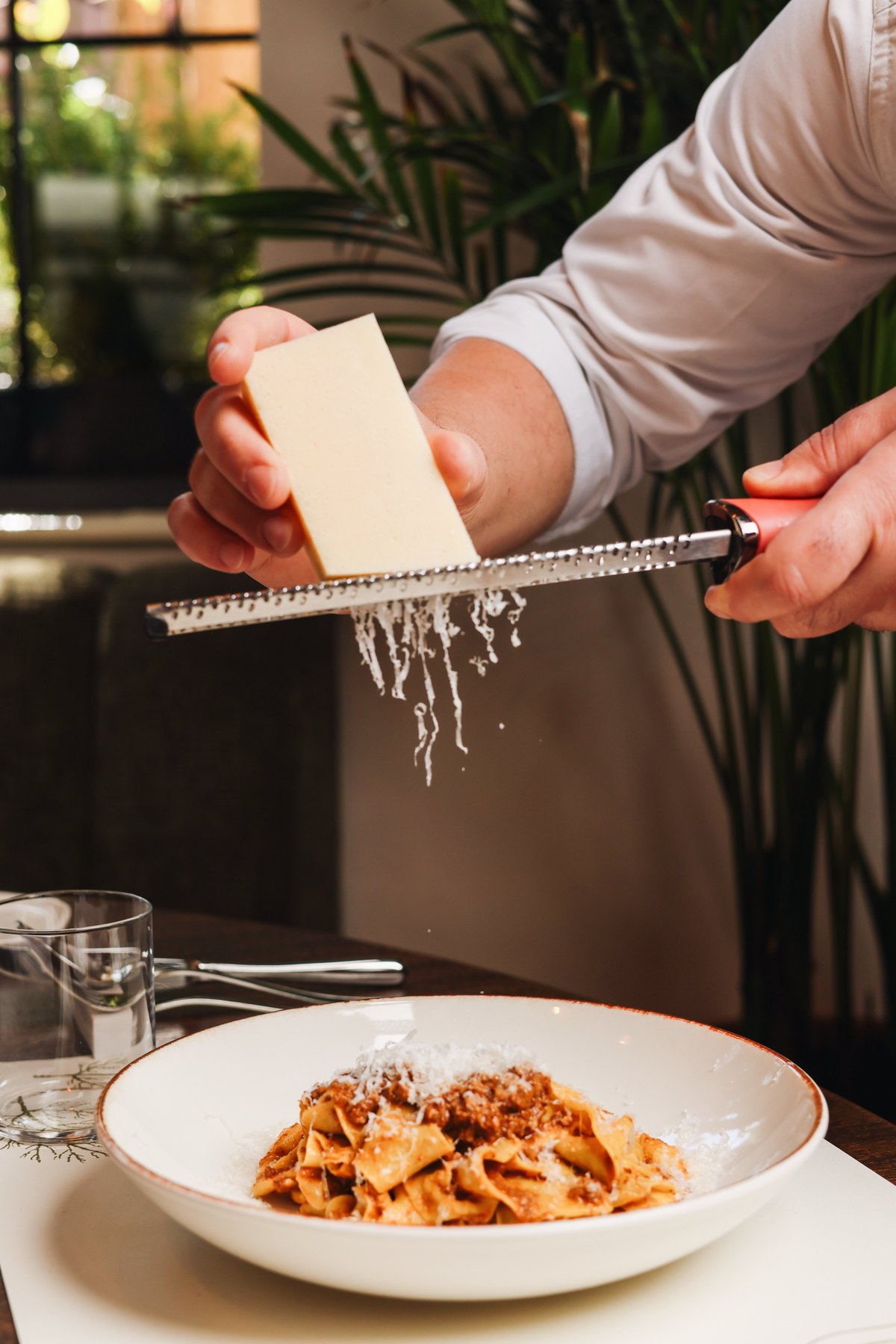 Parmigiano grated over tagliatelle al ragù