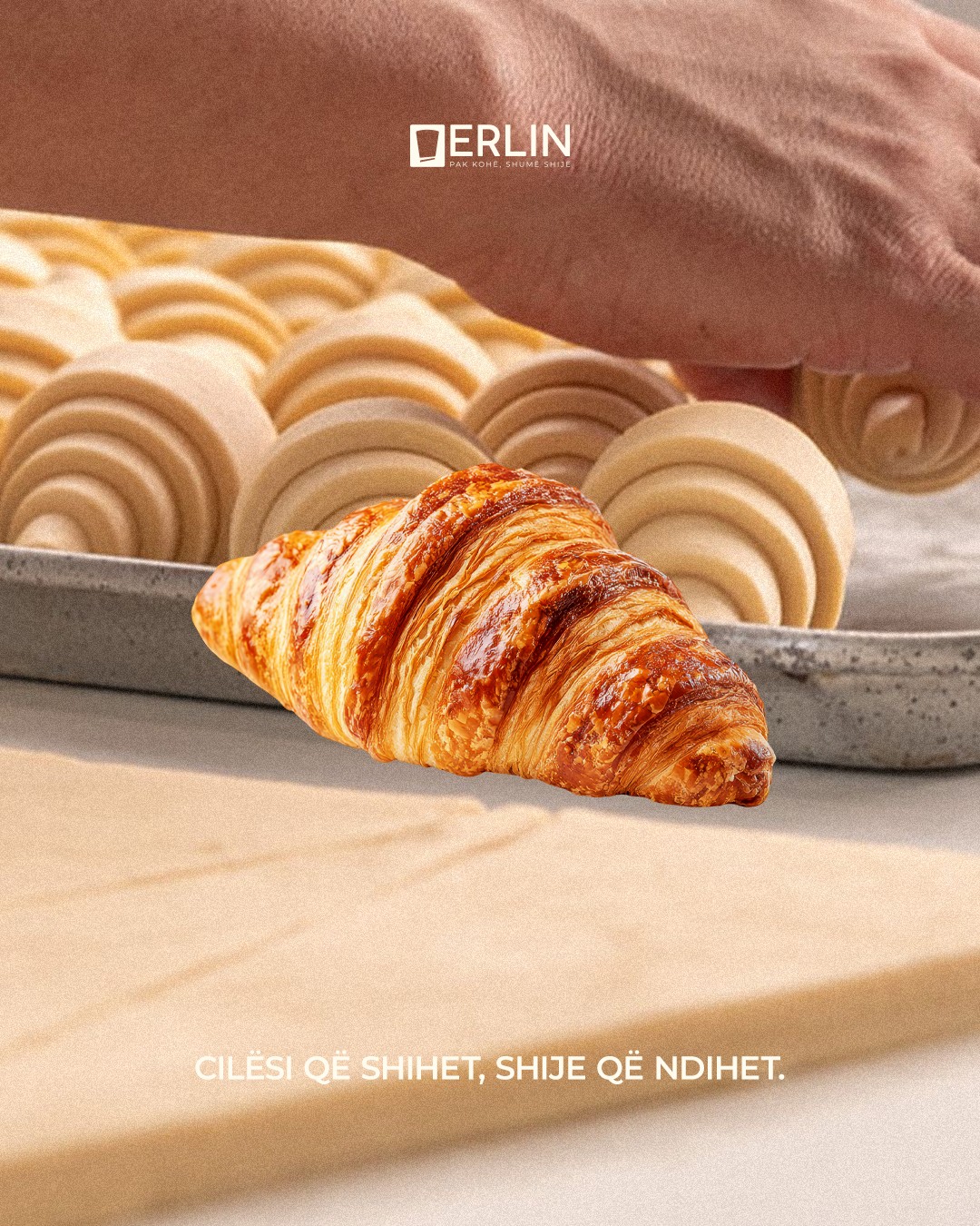 Croissant floating over trays of rolled dough