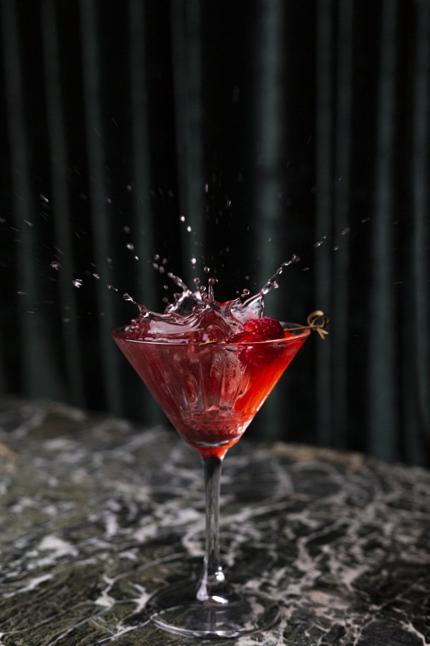 Raspberry martini splashing on green marble