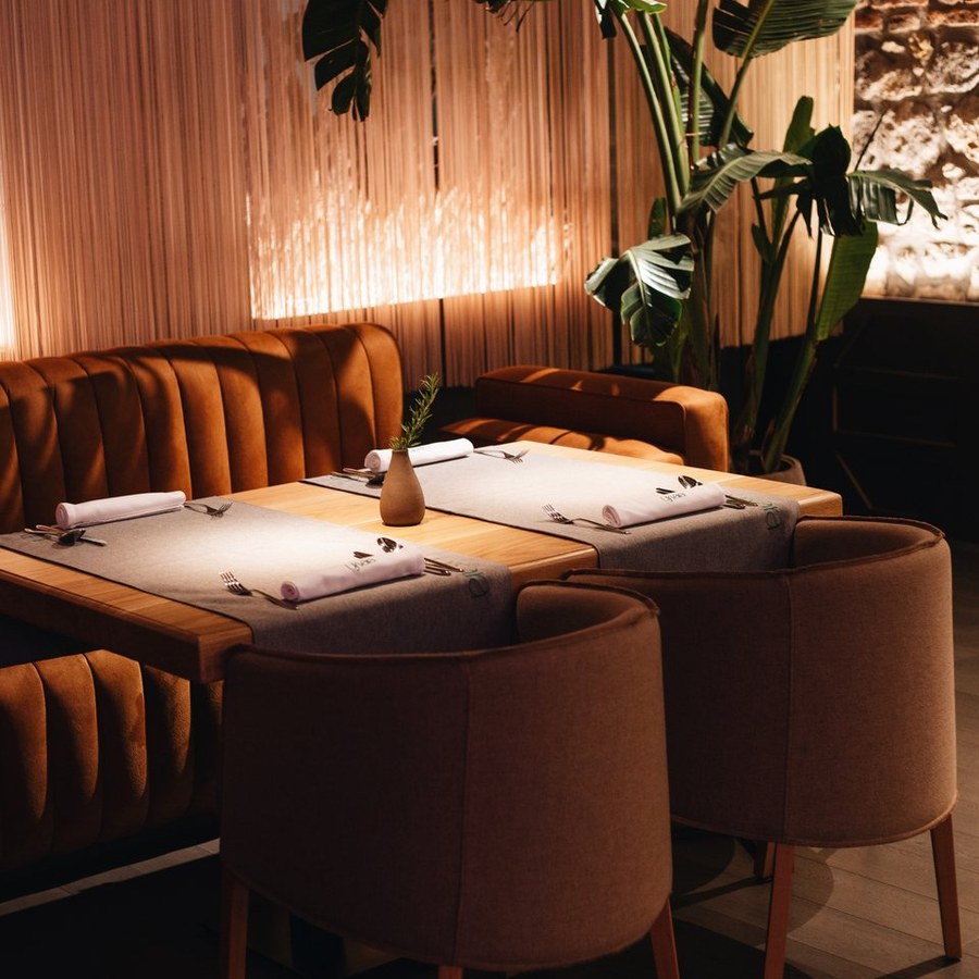 Ujvara dining room with velvet booth and set table