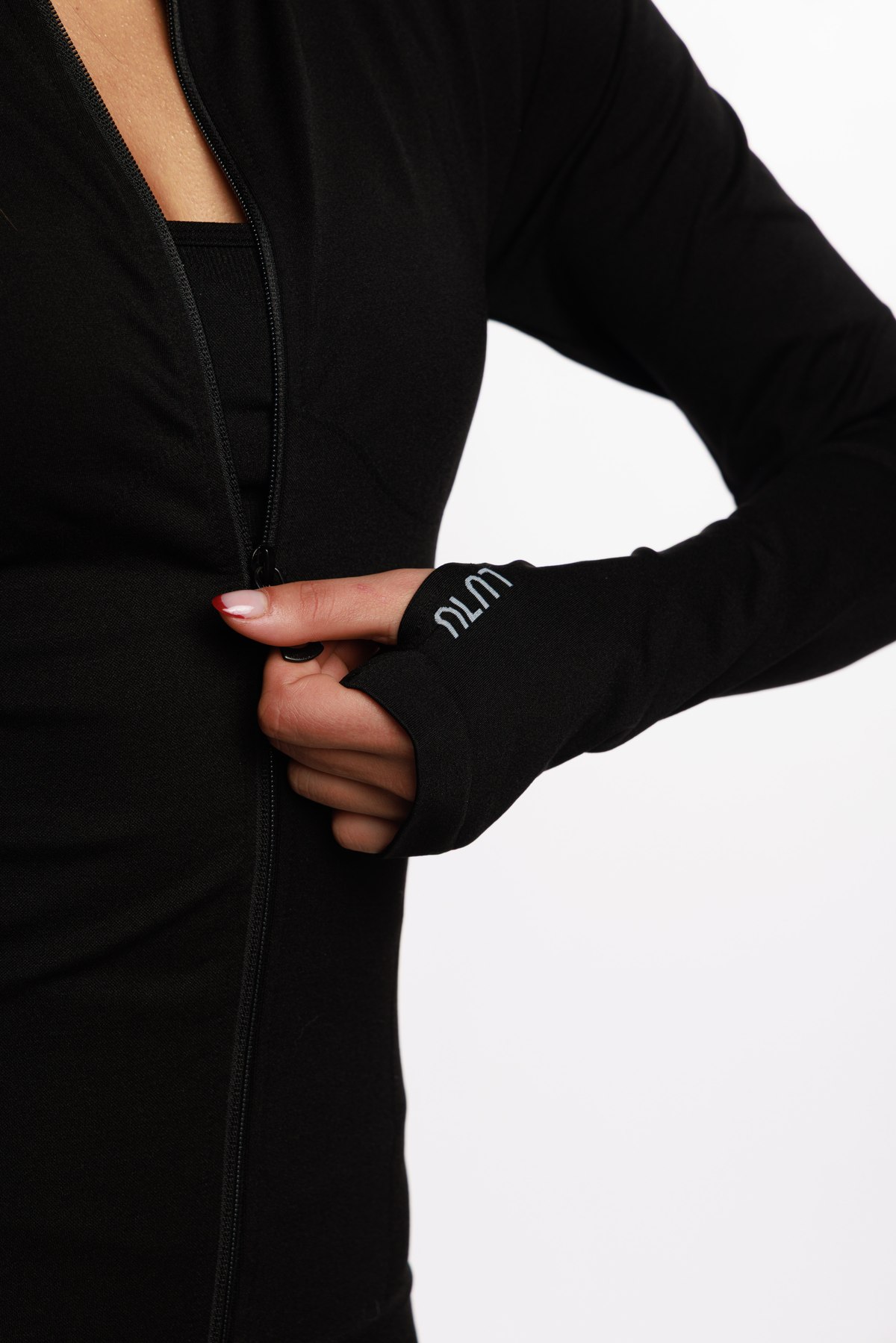 Close-up of the LULU logo on the thumbhole cuff of a black zip jacket