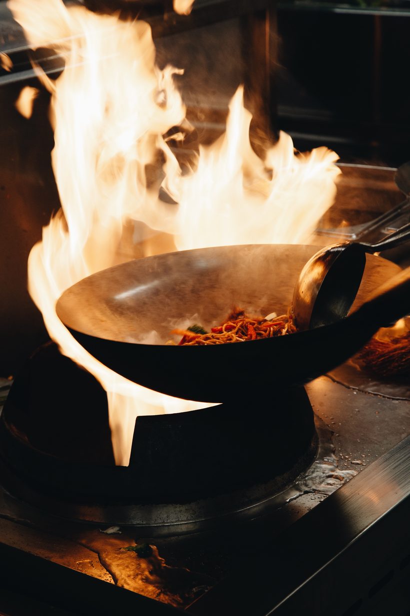 Noodles tossed in a wok over high flames