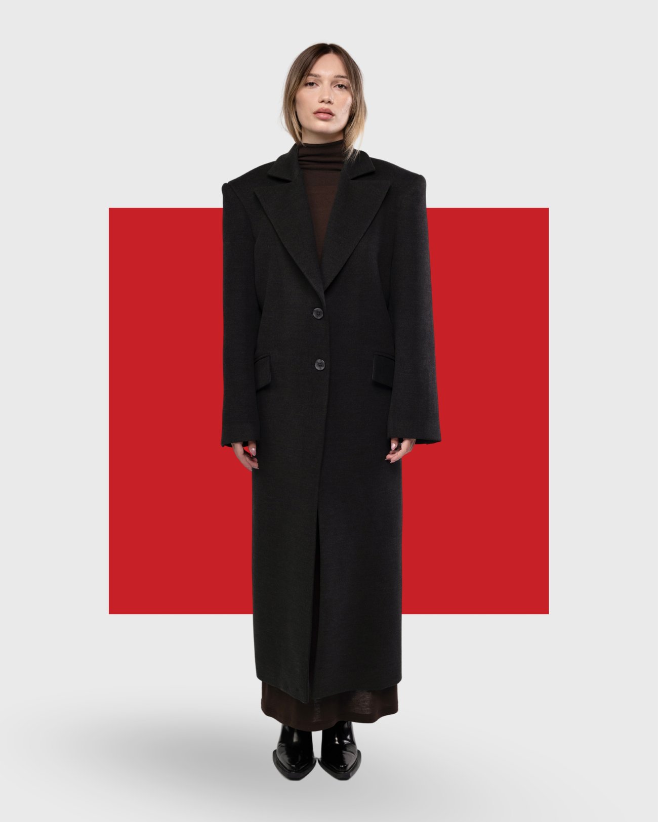 Long charcoal coat against a red block