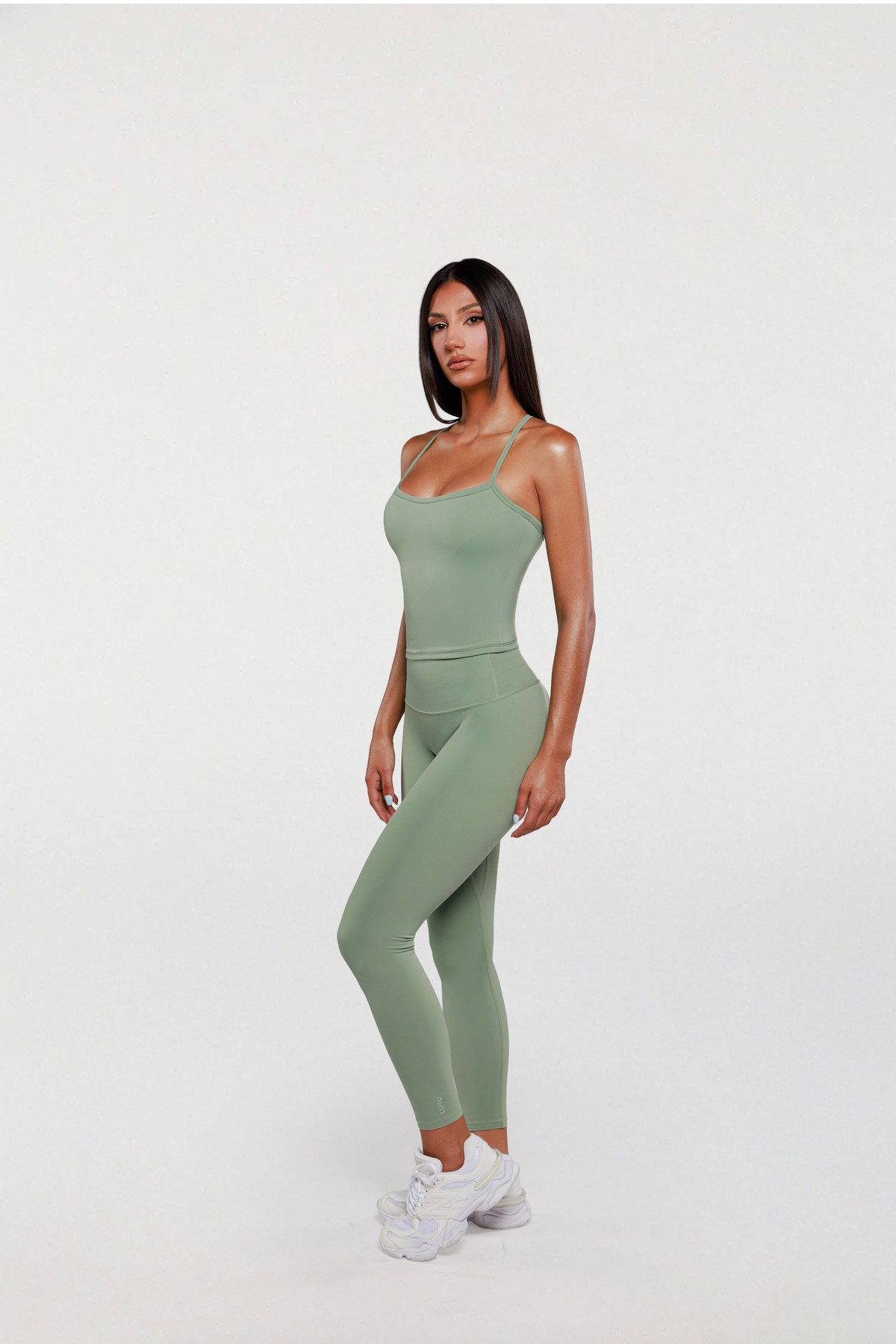 Model in a sage green LULU tank top and leggings, full length