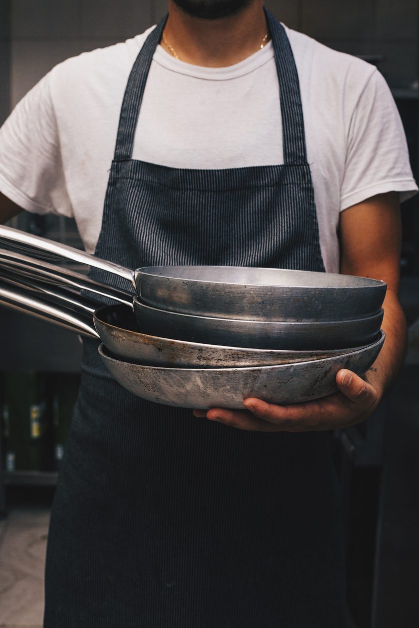 Chef holding a stack of pans in the hotel kitchen