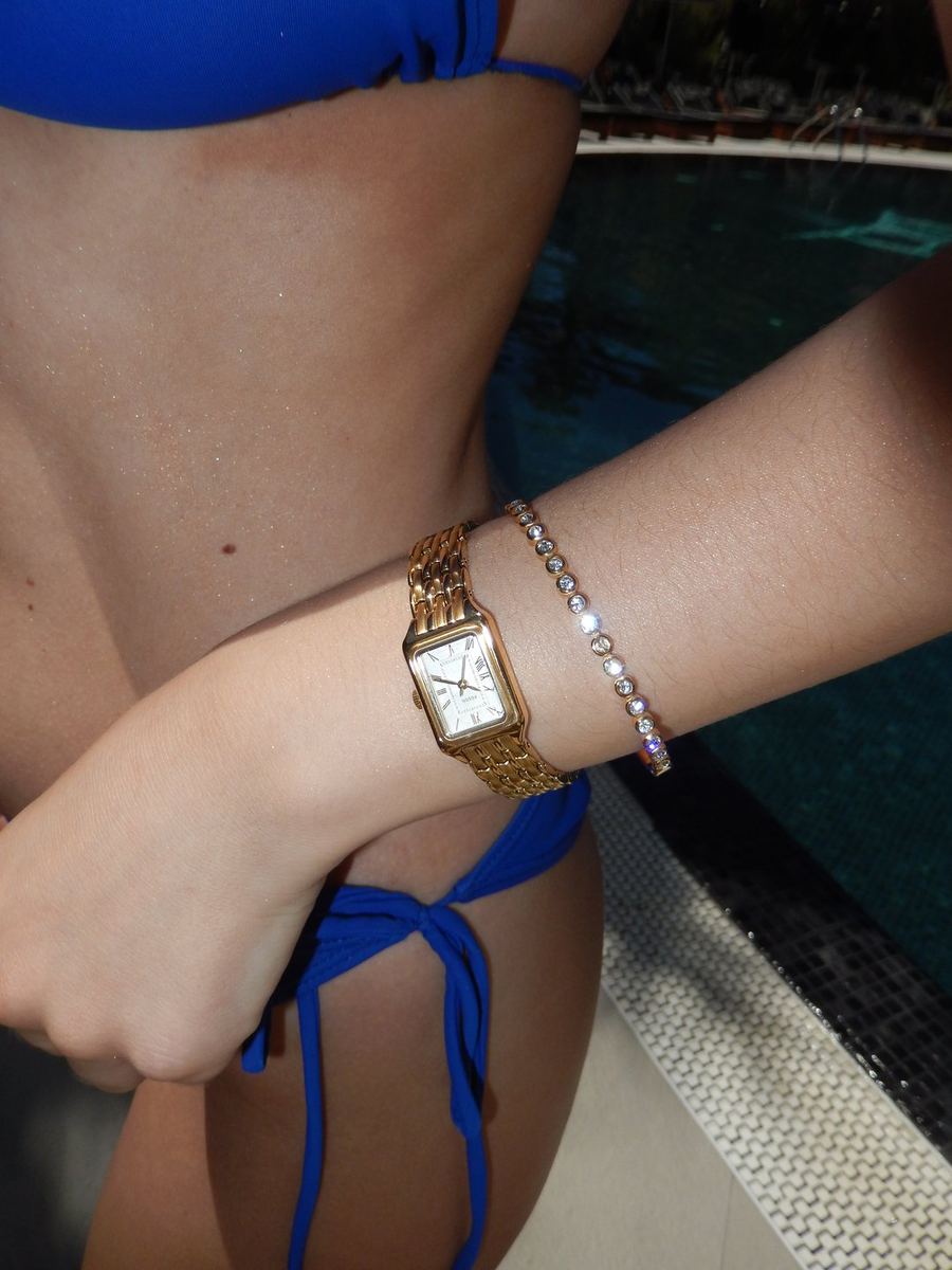 Gold Fossil watch and bracelet by the pool