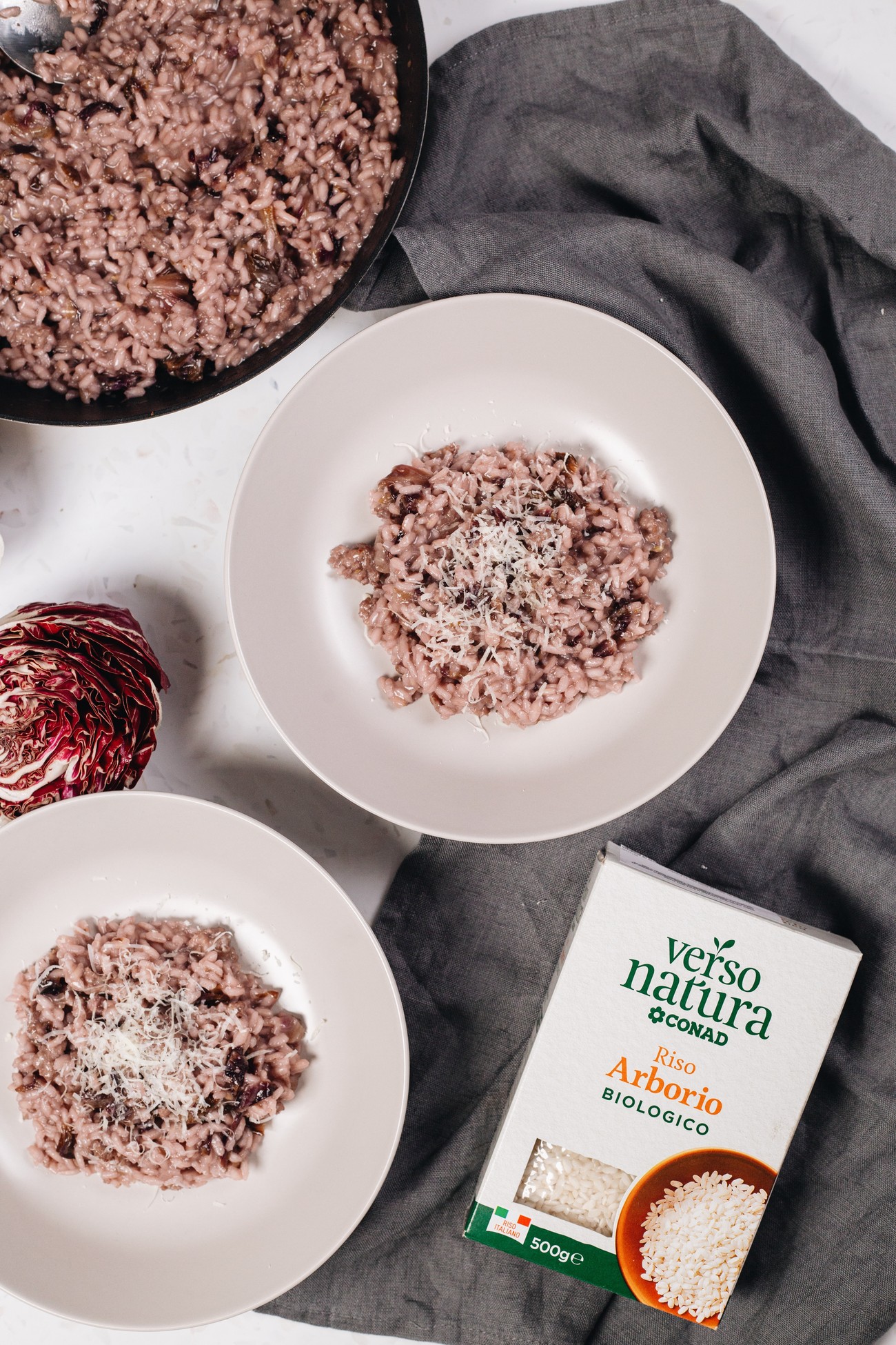 Radicchio risotto in two bowls with a box of Verso Natura Arborio rice