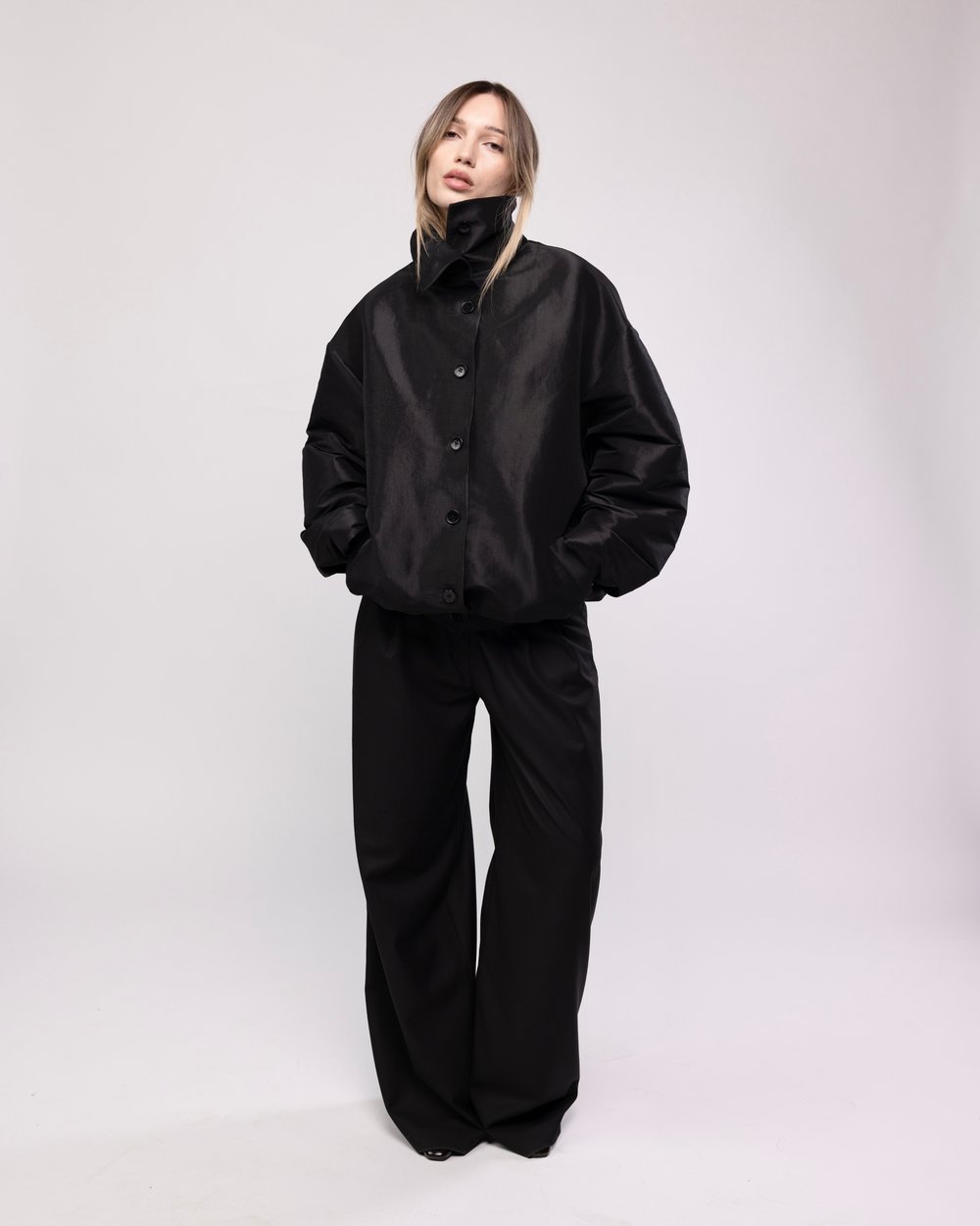 Black satin bomber with a raised collar and wide trousers
