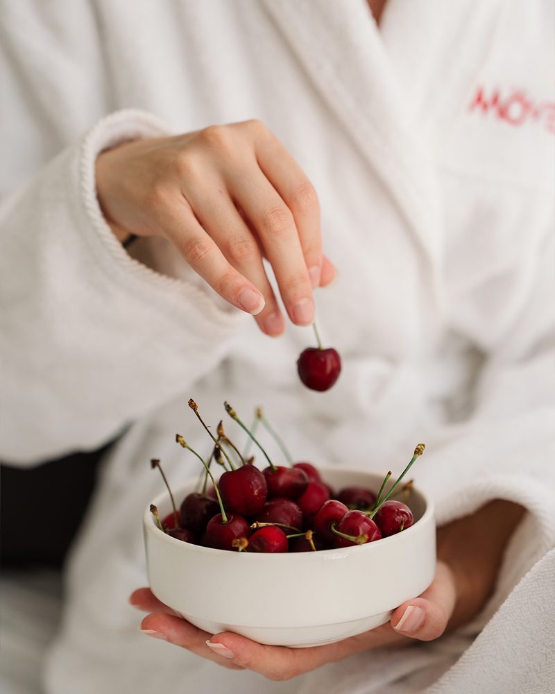 Picking cherries from a bowl in a Mövenpick robe