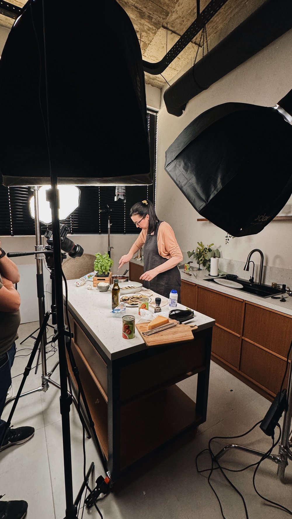 The studio kitchen lit for a food shoot, with a stylist at work