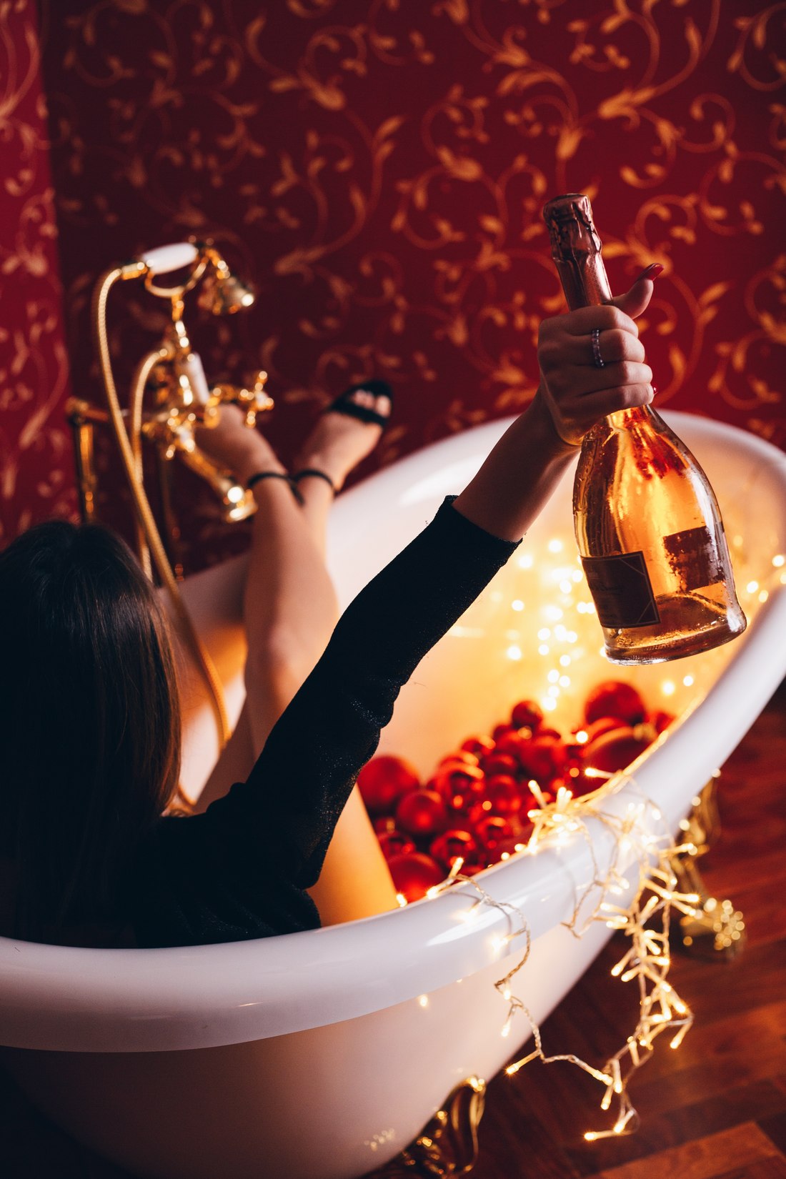 Guest in a festive bath raising a bottle of sparkling wine