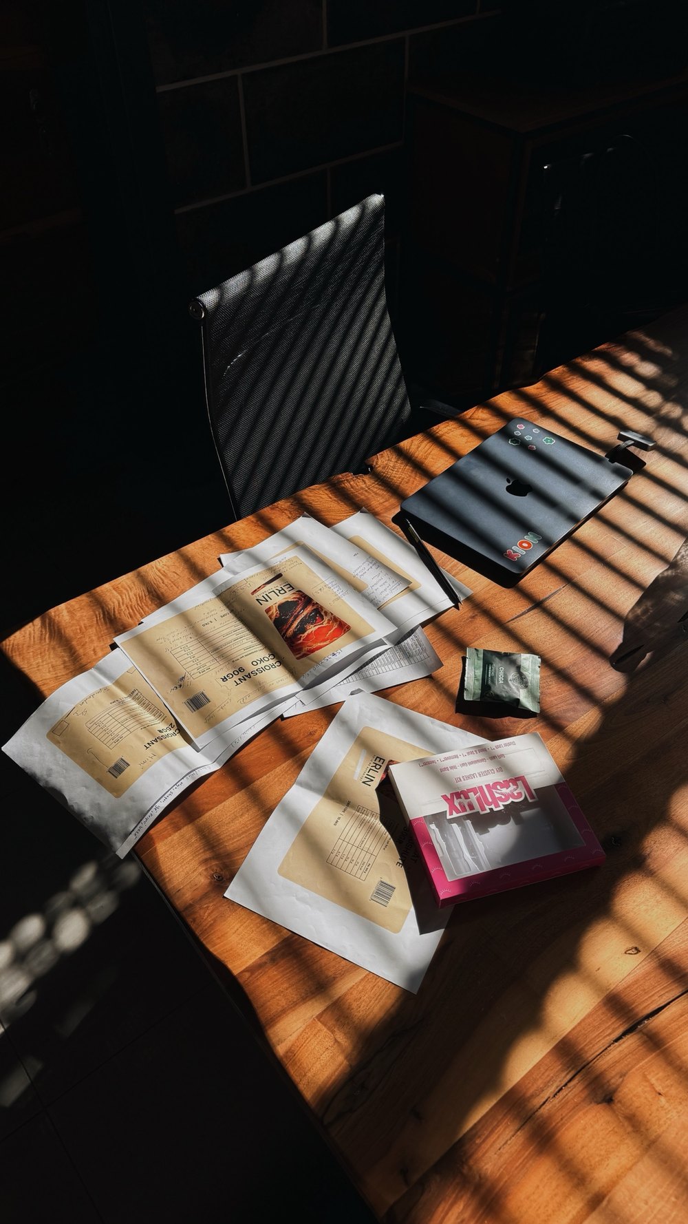 Packaging samples and layouts on the studio table in afternoon light