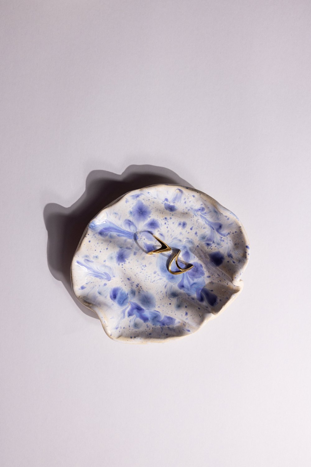 Gold rings in a blue speckled hand-made ceramic dish
