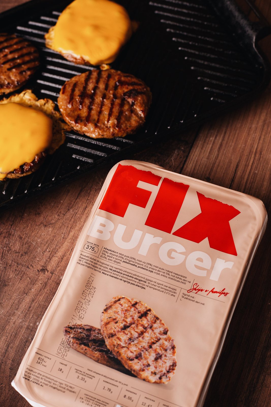 FIX Burger pack beside patties with melted cheese on the grill