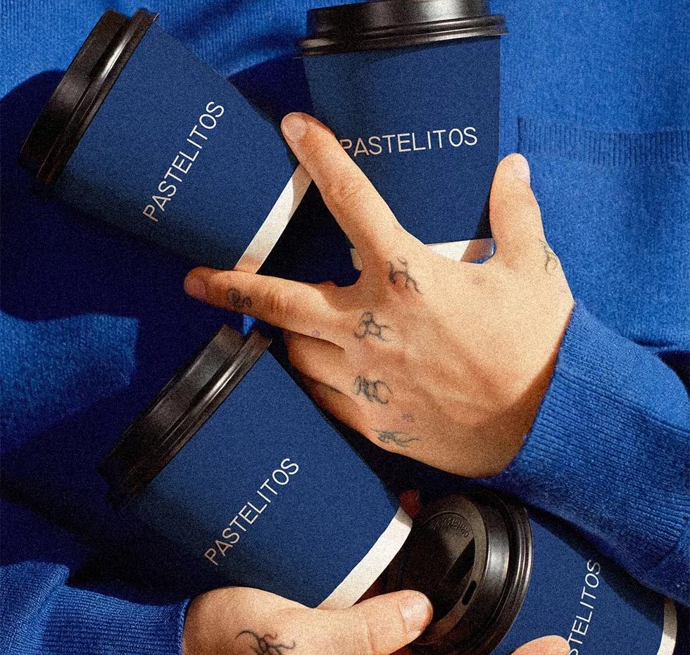 Hands holding Pastelitos branded coffee cups