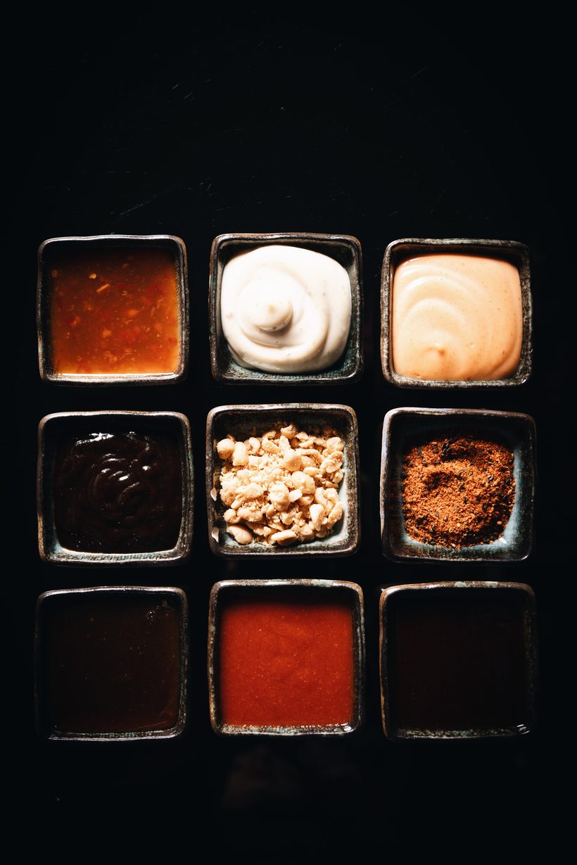 Nine dipping sauces and toppings in square bowls