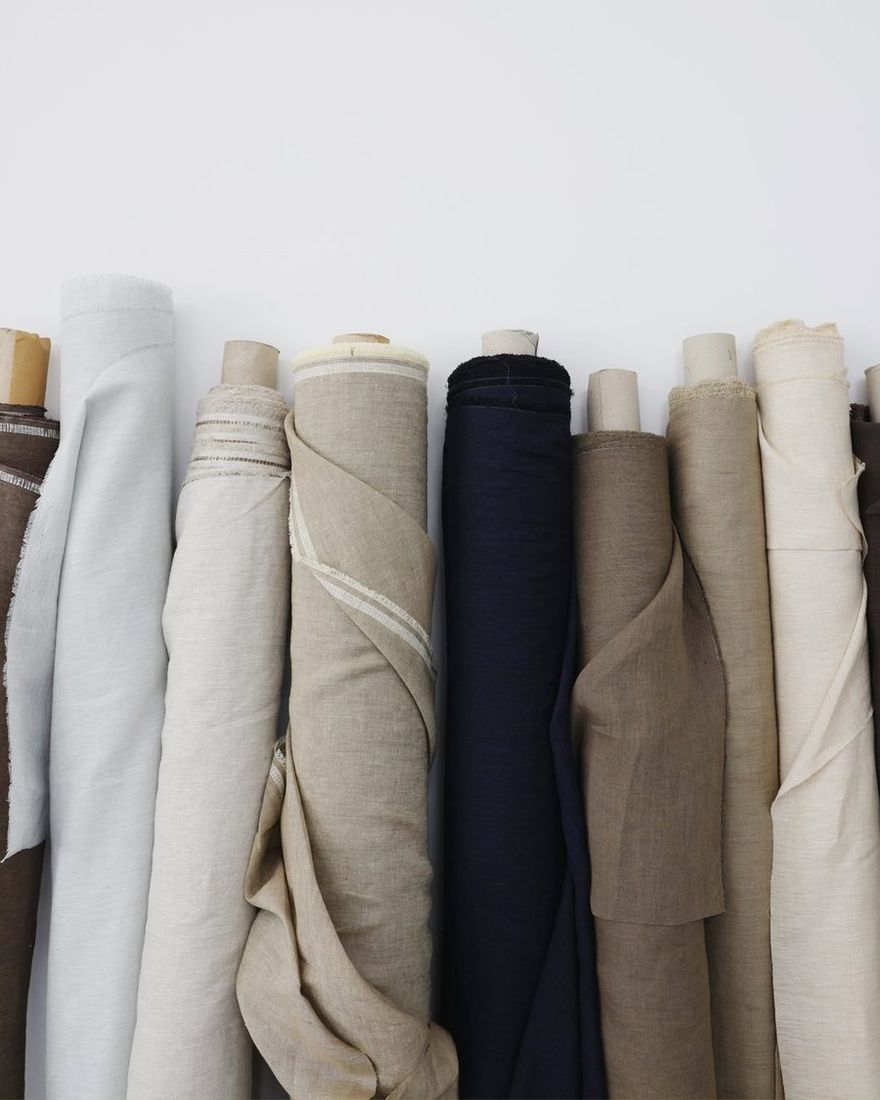 Rolls of linen fabric in white, beige, brown and navy