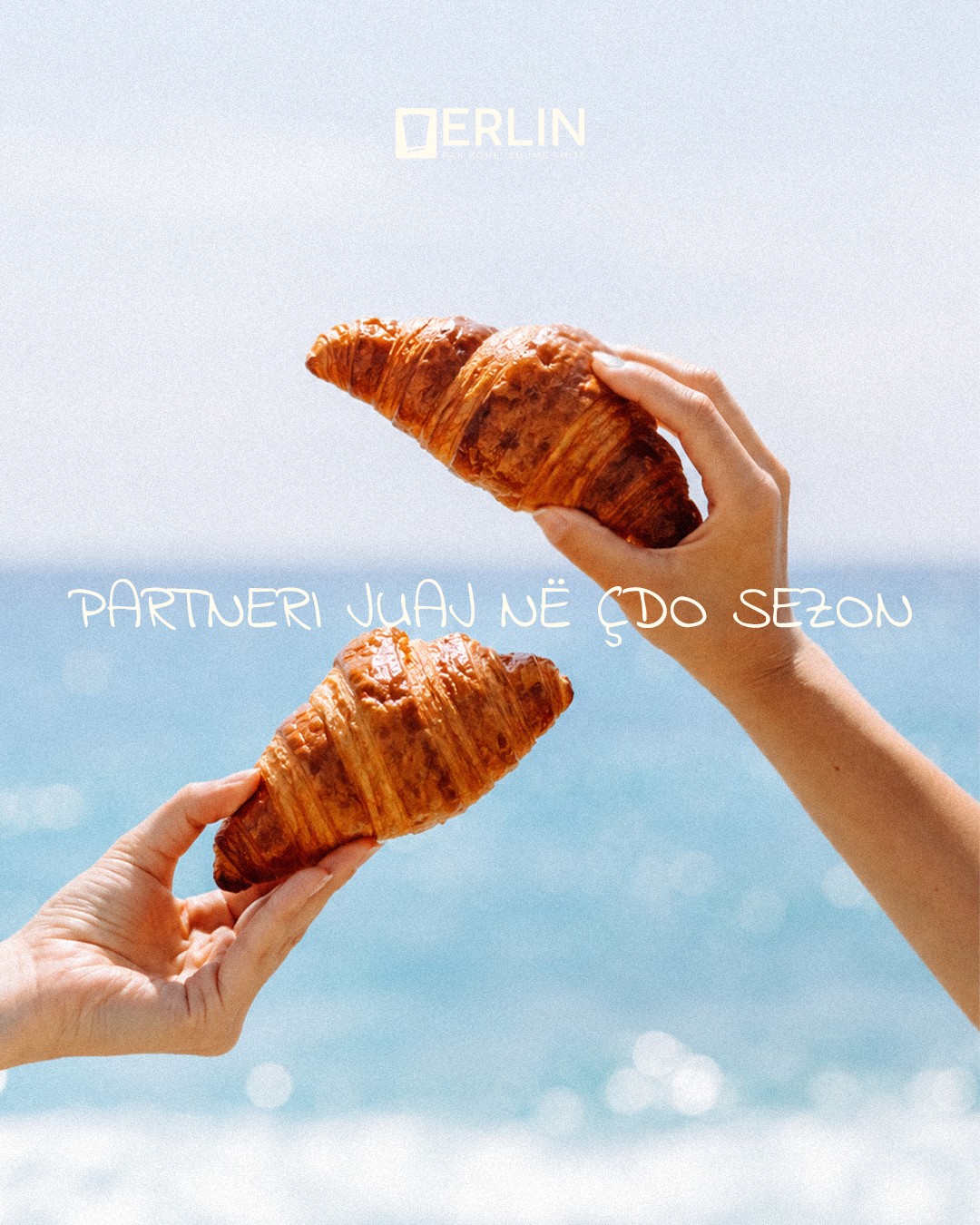 Two croissants held up against the sea, your partner every season