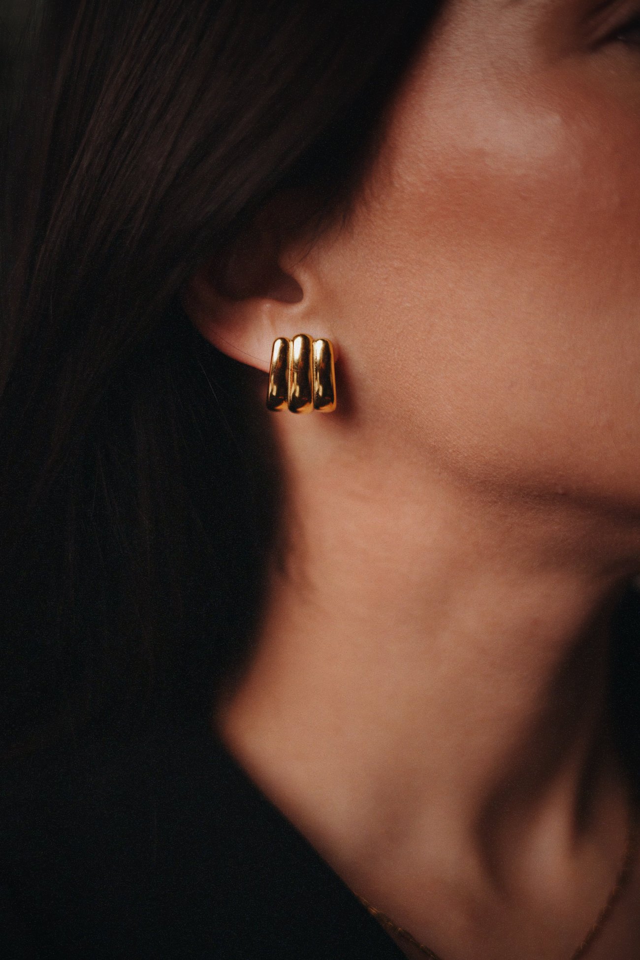 Close-up of a gold triple-dome earring