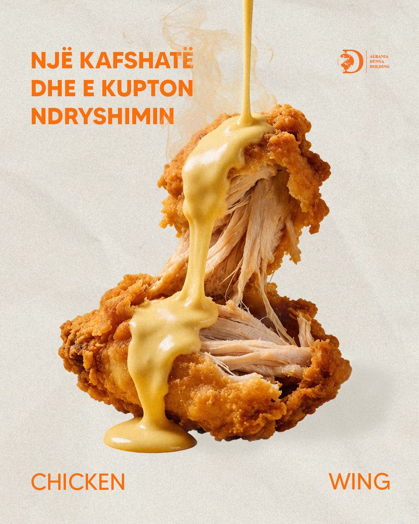 Chicken wing pulled apart under a stream of cheese sauce
