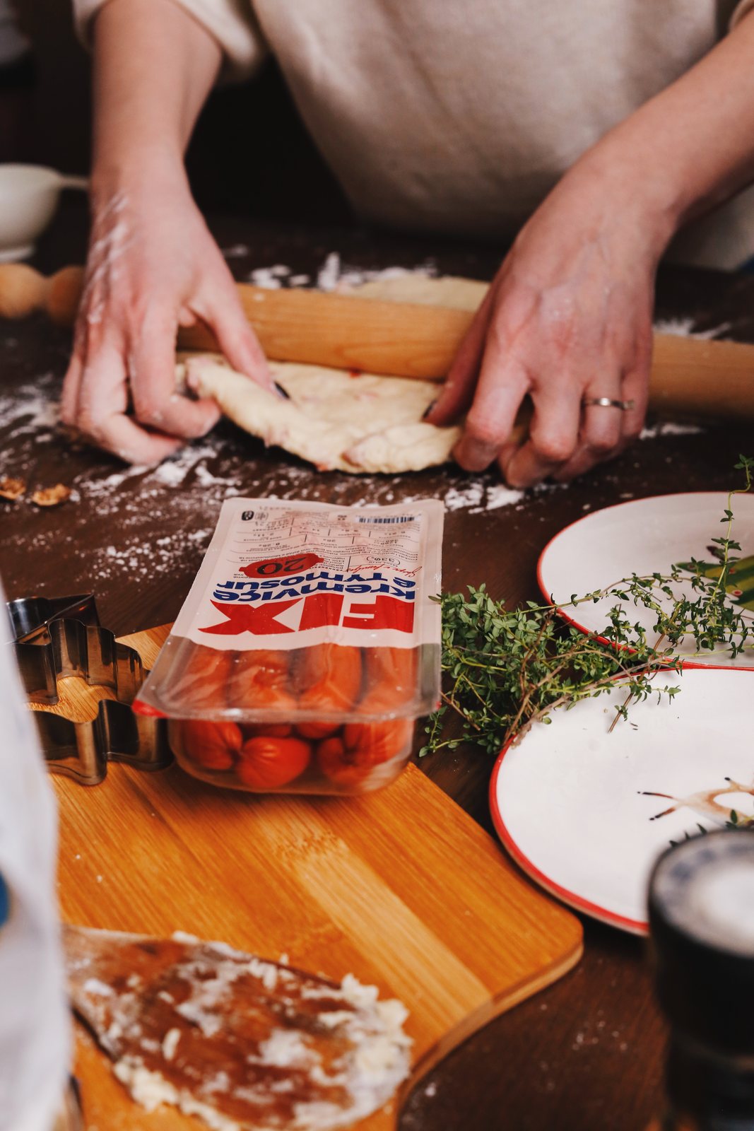 Hands rolling dough beside a pack of FIX smoked frankfurters