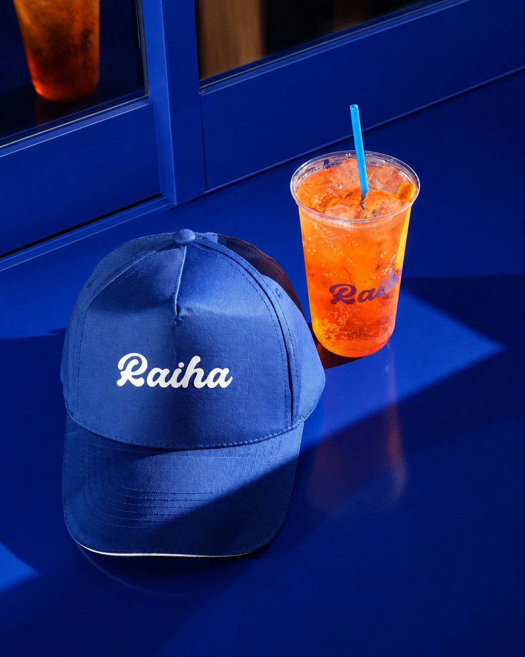 Raiha cap and orange drink on a cobalt window ledge