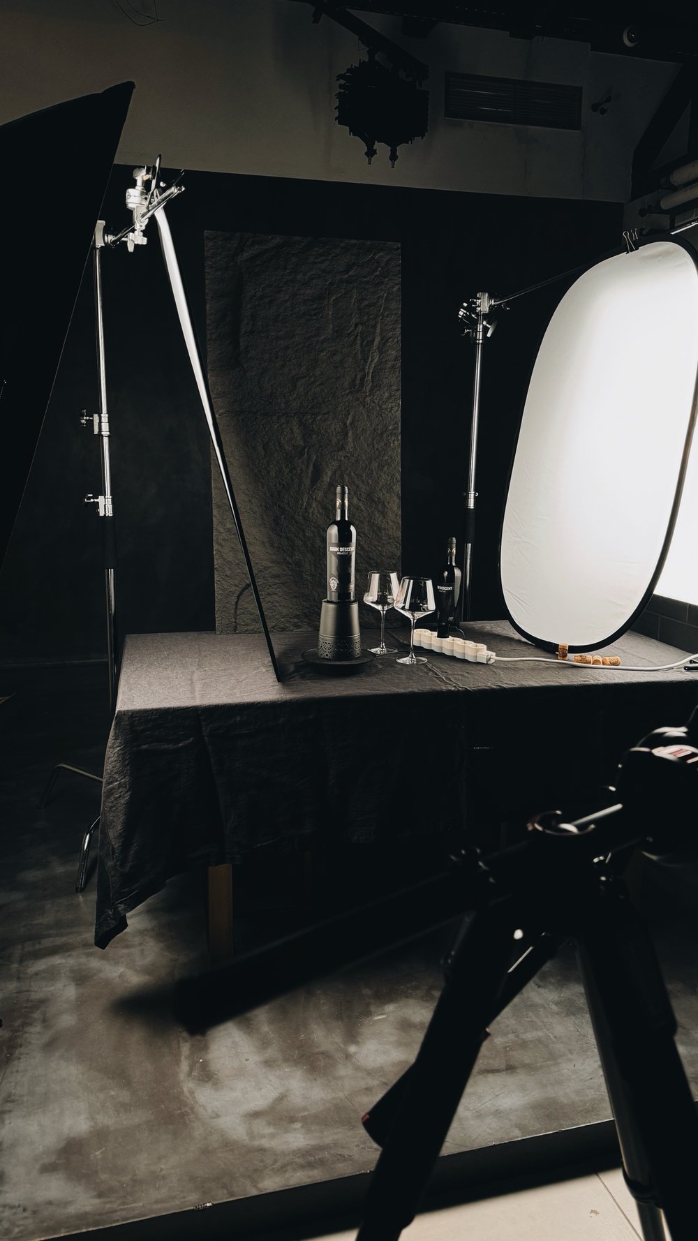 A dark set built for a wine shoot, with flags and a reflector
