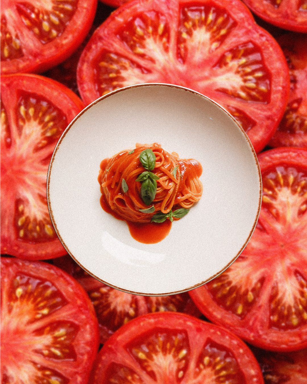 Spaghetti al pomodoro on a bed of sliced tomatoes