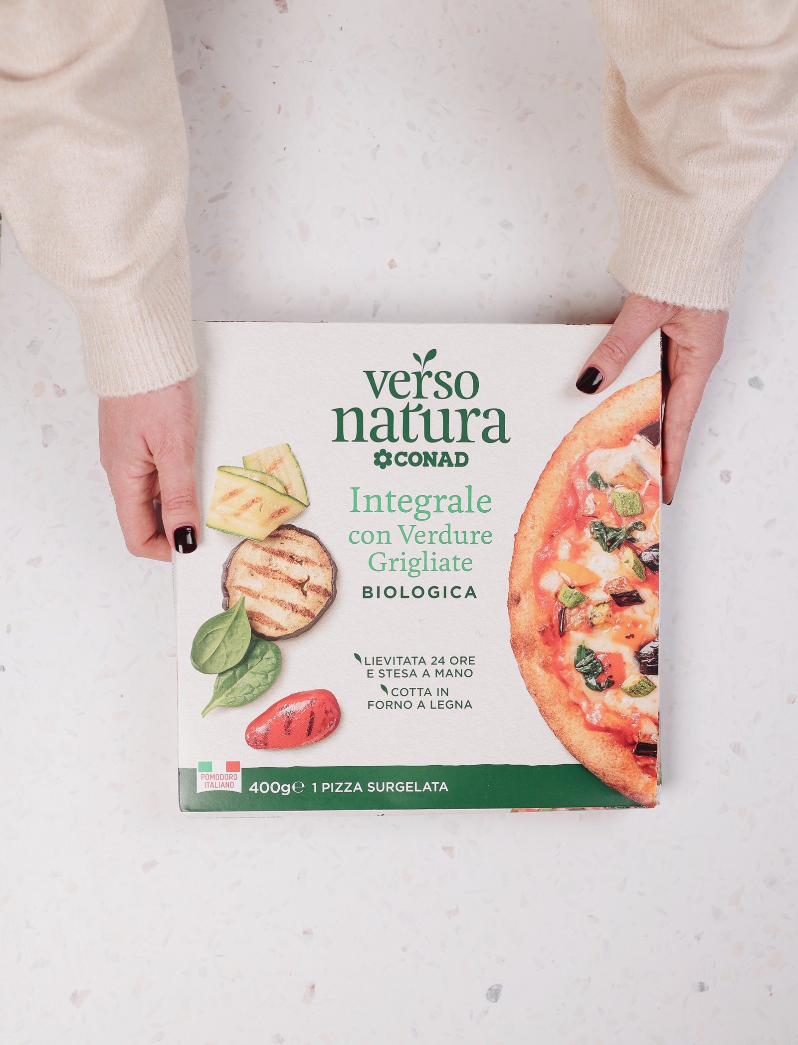 Hands holding a Verso Natura wholegrain pizza with grilled vegetables box