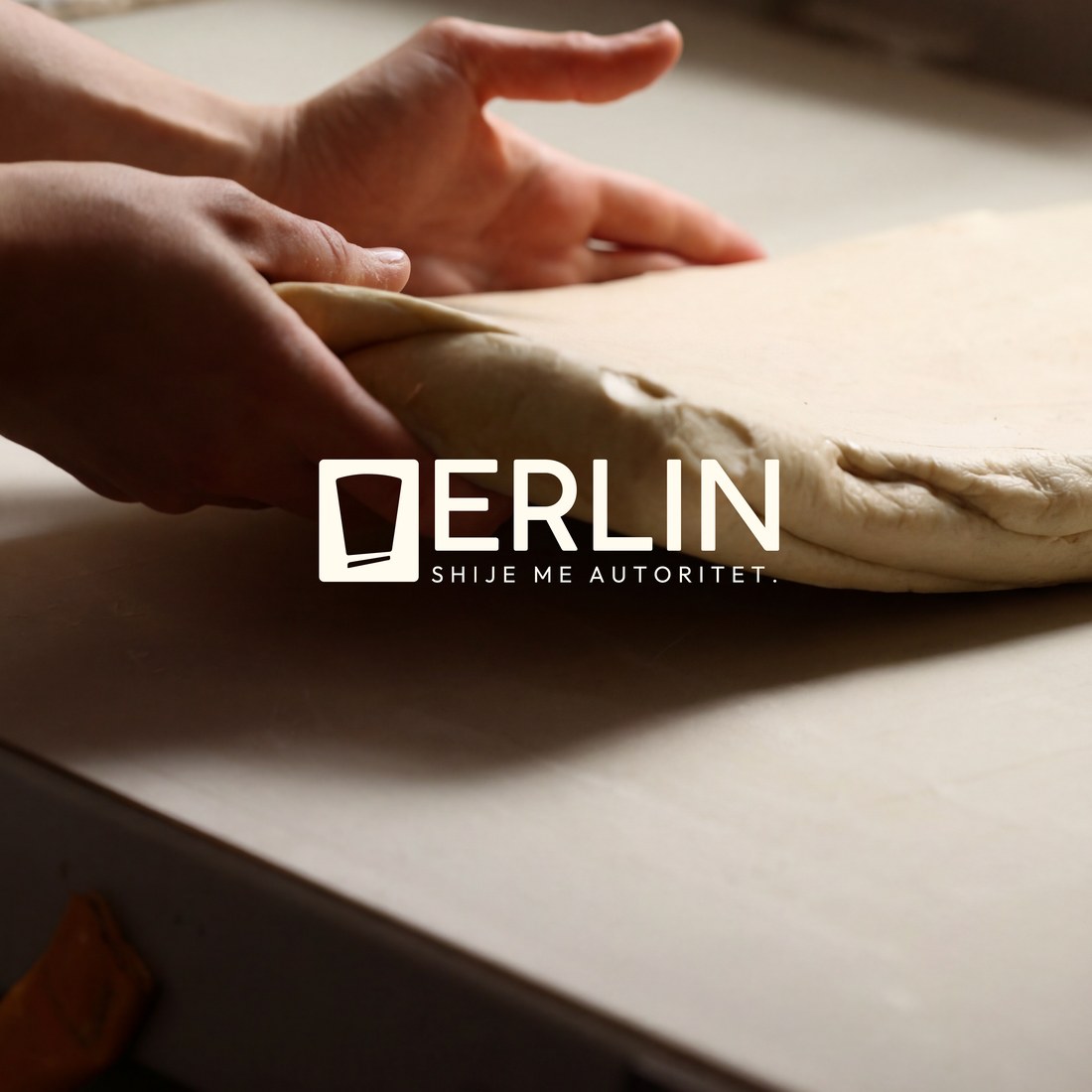 Hands shaping dough with the Erlin logo overlaid