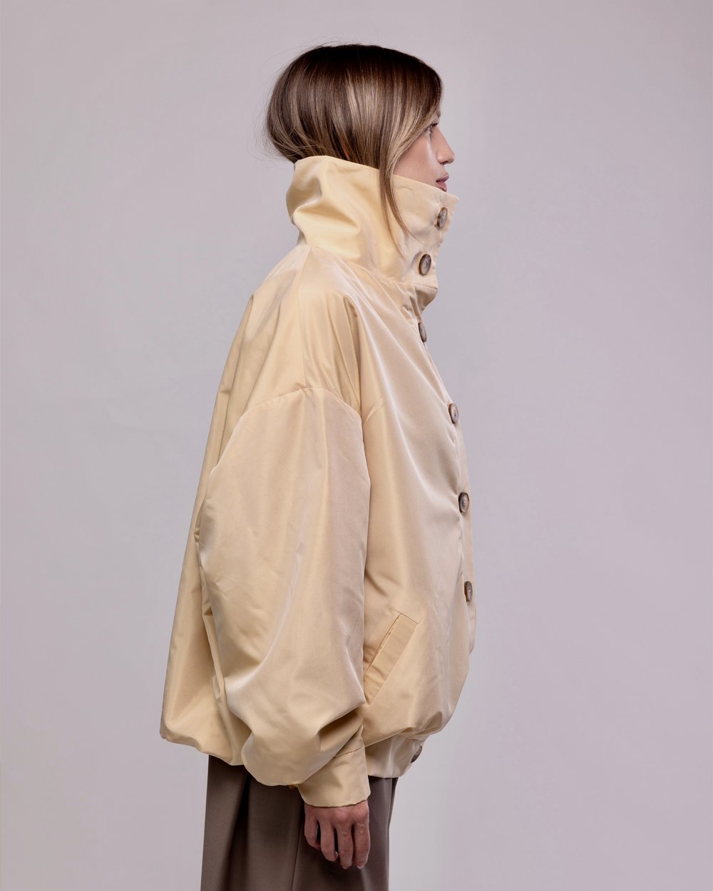 Cream bomber jacket seen in profile