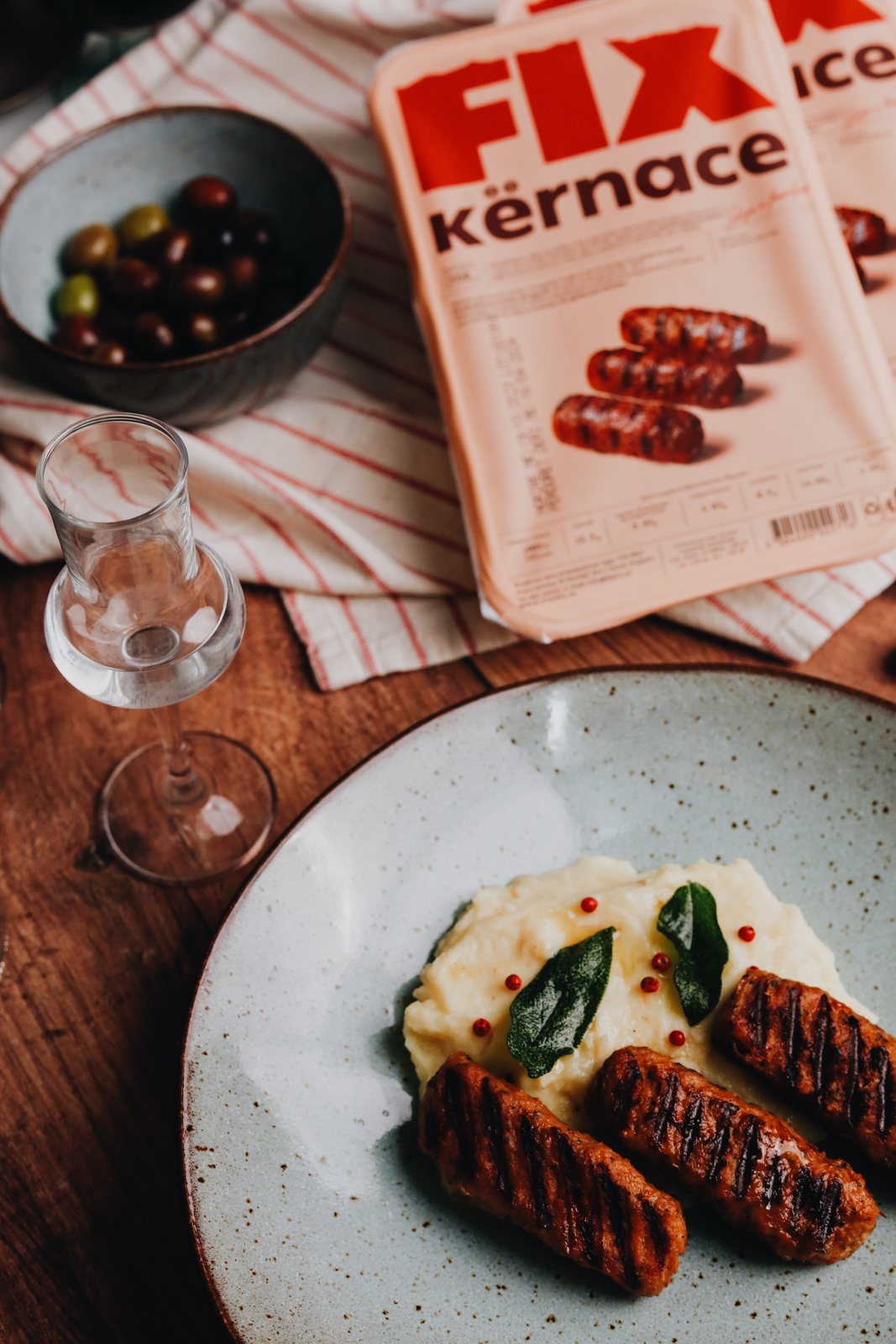 FIX kërnace grilled on a plate with mashed potatoes and a raki glass