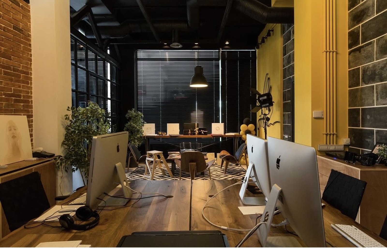 The Bloom Studios workspace, with desks, plants and the meeting table beyond