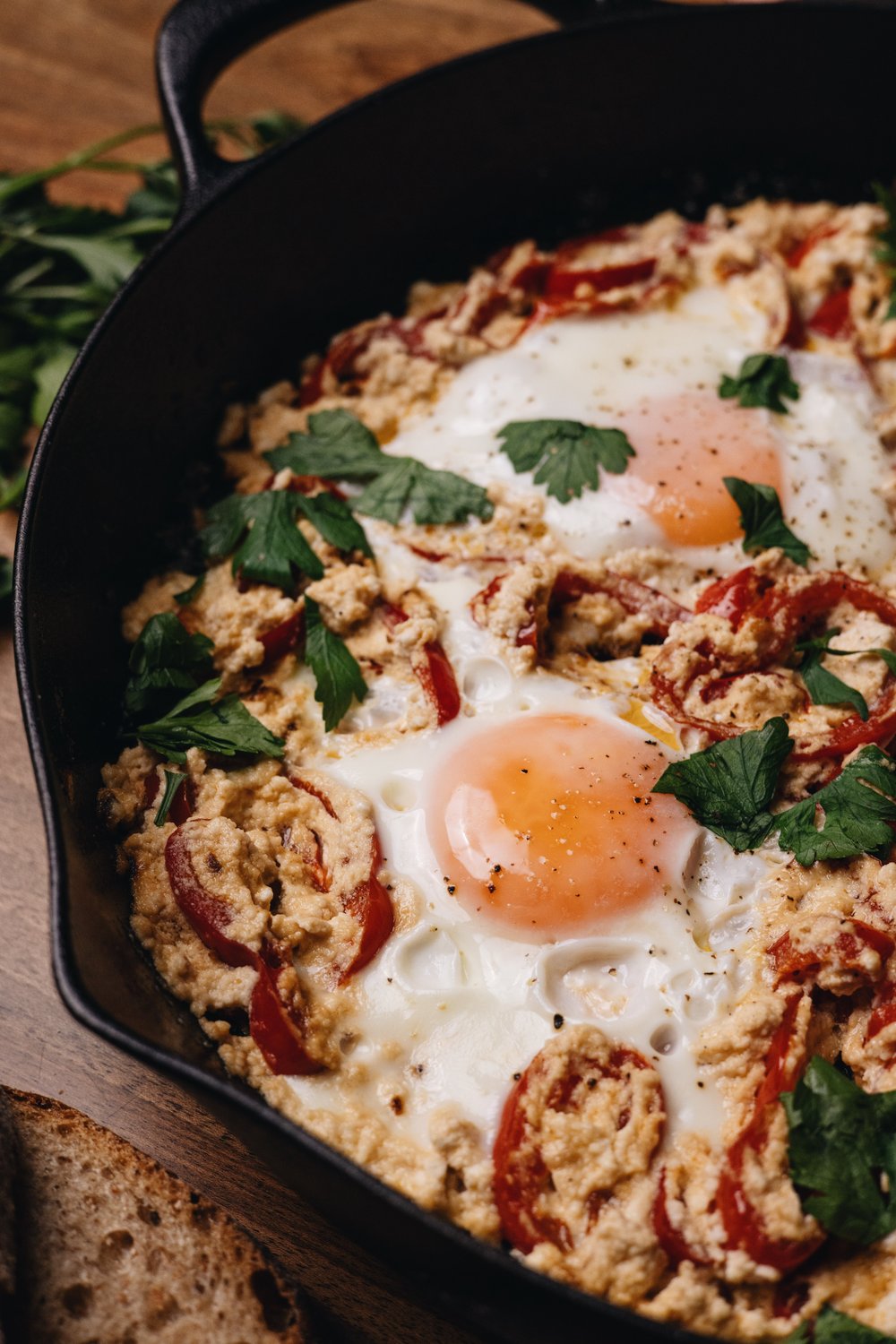 Baked eggs with tomatoes and herbs in a cast iron skillet