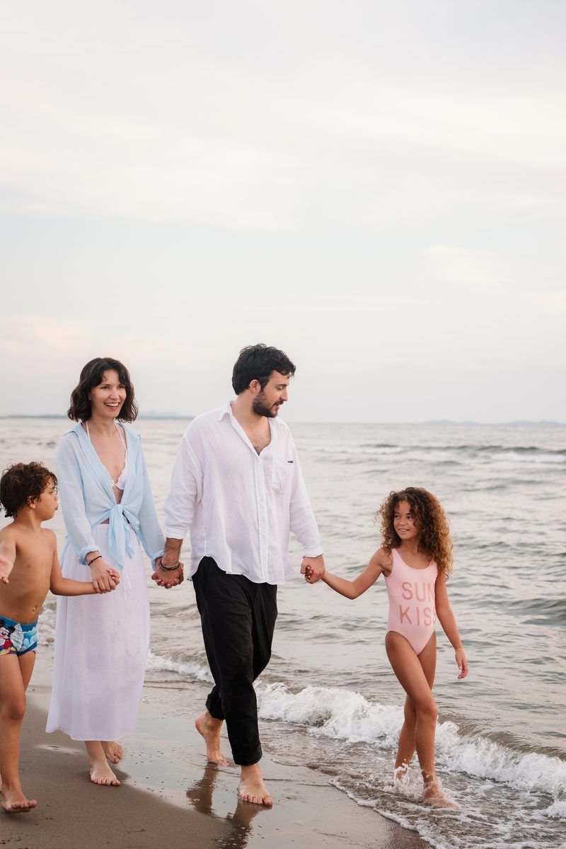 Family walking hand in hand along the beach