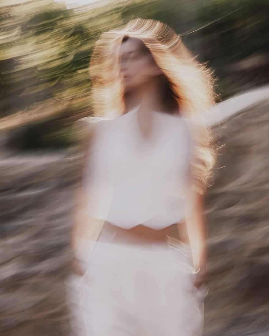 Motion-blurred model in a white TIERR co-ord with her hair in the wind
